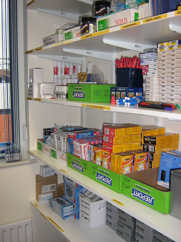 Retail shelves stocked with pens, pencils, stationery accessories, and school supplies